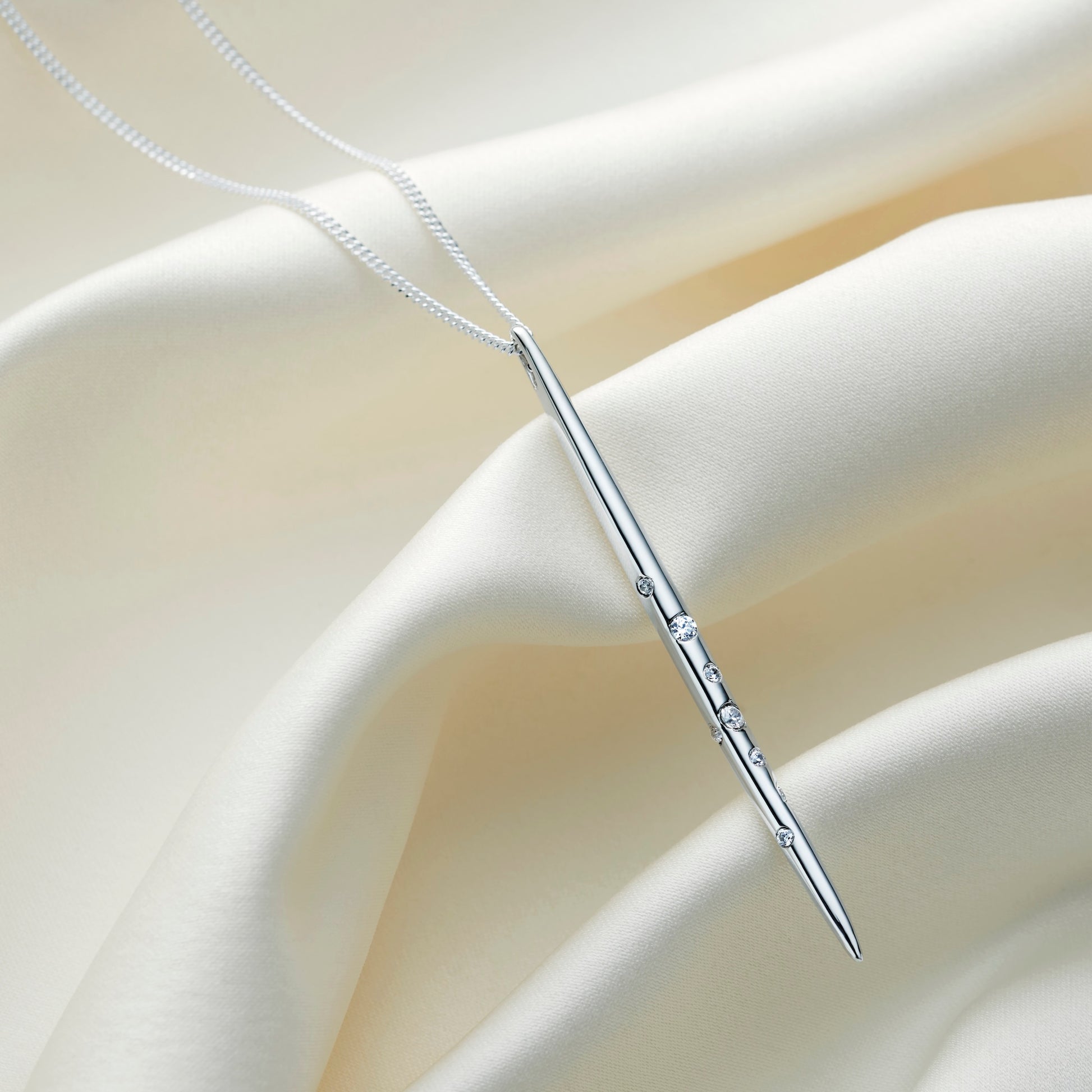 Highly polished sterling silver Virgo constellation necklace with a vertical spike pendant decorated with crystals representing the Virgo constellation, suspended on a delicate silver chain.