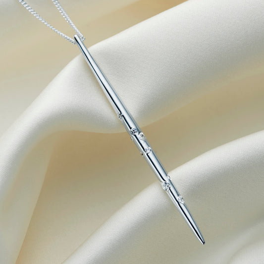 Long silver pendant necklace set with white crystals depicting the constellation of Capricorn.