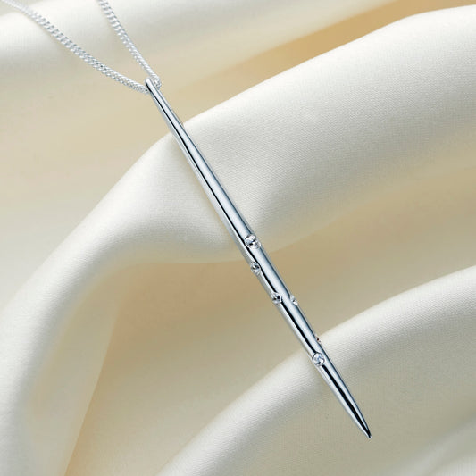 Sterling silver Libra constellation necklace by Claudette Worters, with a highly polished vertical spike pendant adorned with clear Swarovski crystals forming the Libra constellation, hanging on a delicate silver chain.