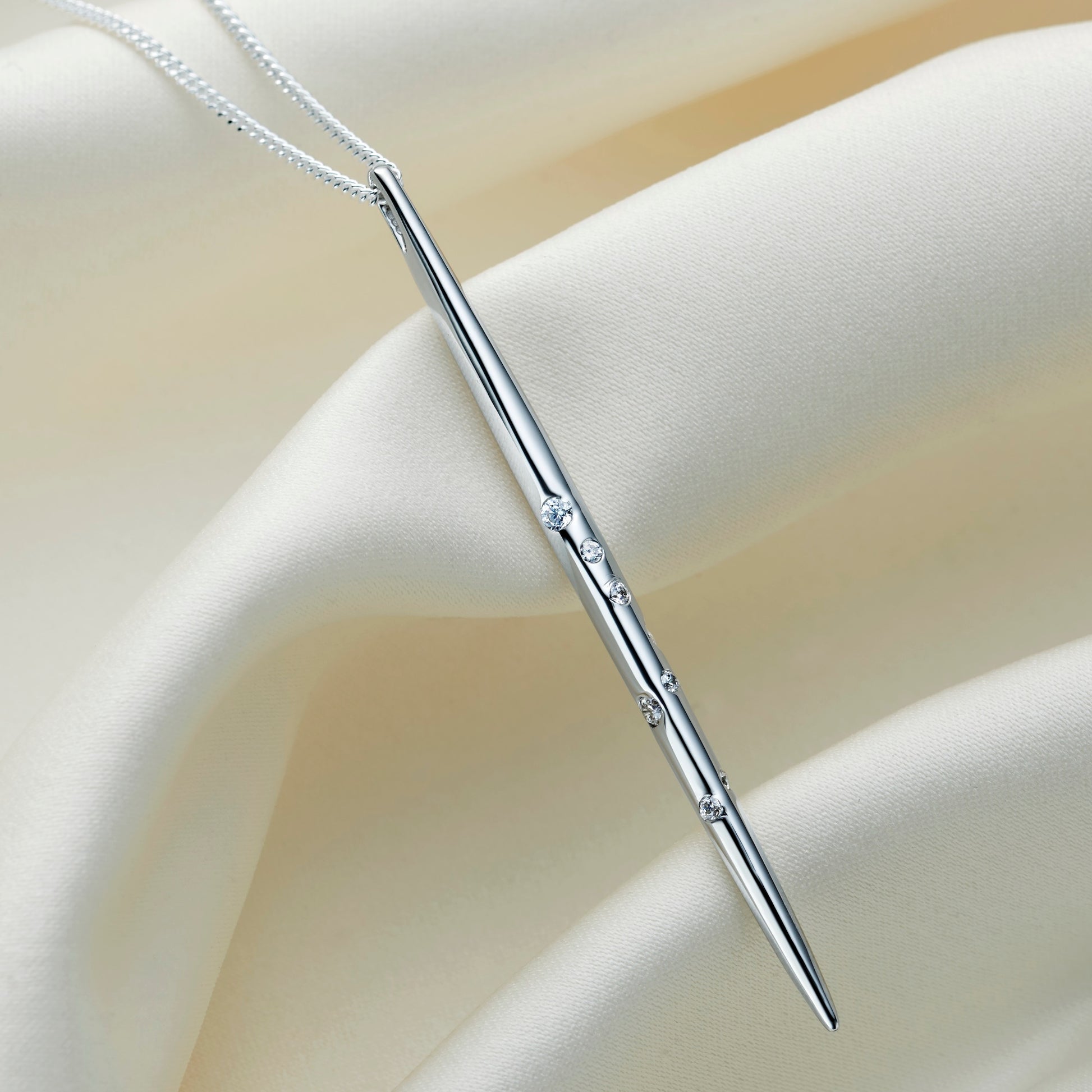 Sterling silver Scorpio constellation necklace by Claudette Worters, with a highly polished vertical spike pendant adorned with clear Swarovski crystals forming the Scorpio constellation, on a delicate silver chain.